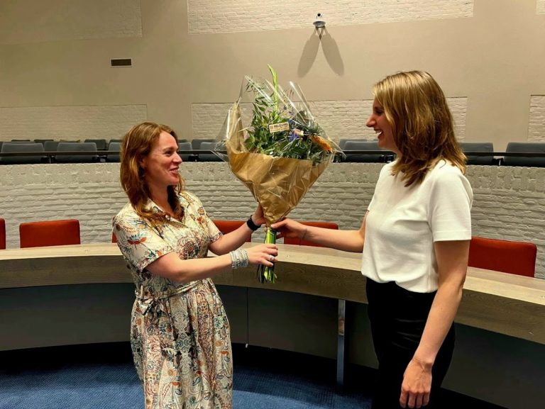 Anne Sterenberg links op de foto krijgt bloemen van de scheidende wethouder, Lisa van Aalst.