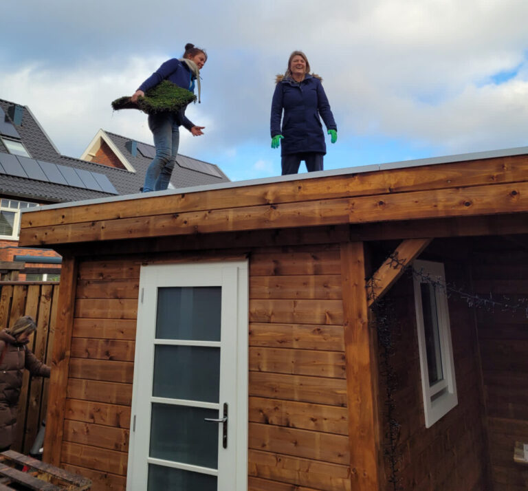 Wethouder Treep met Leonie op een groen dak in Soesterberg
